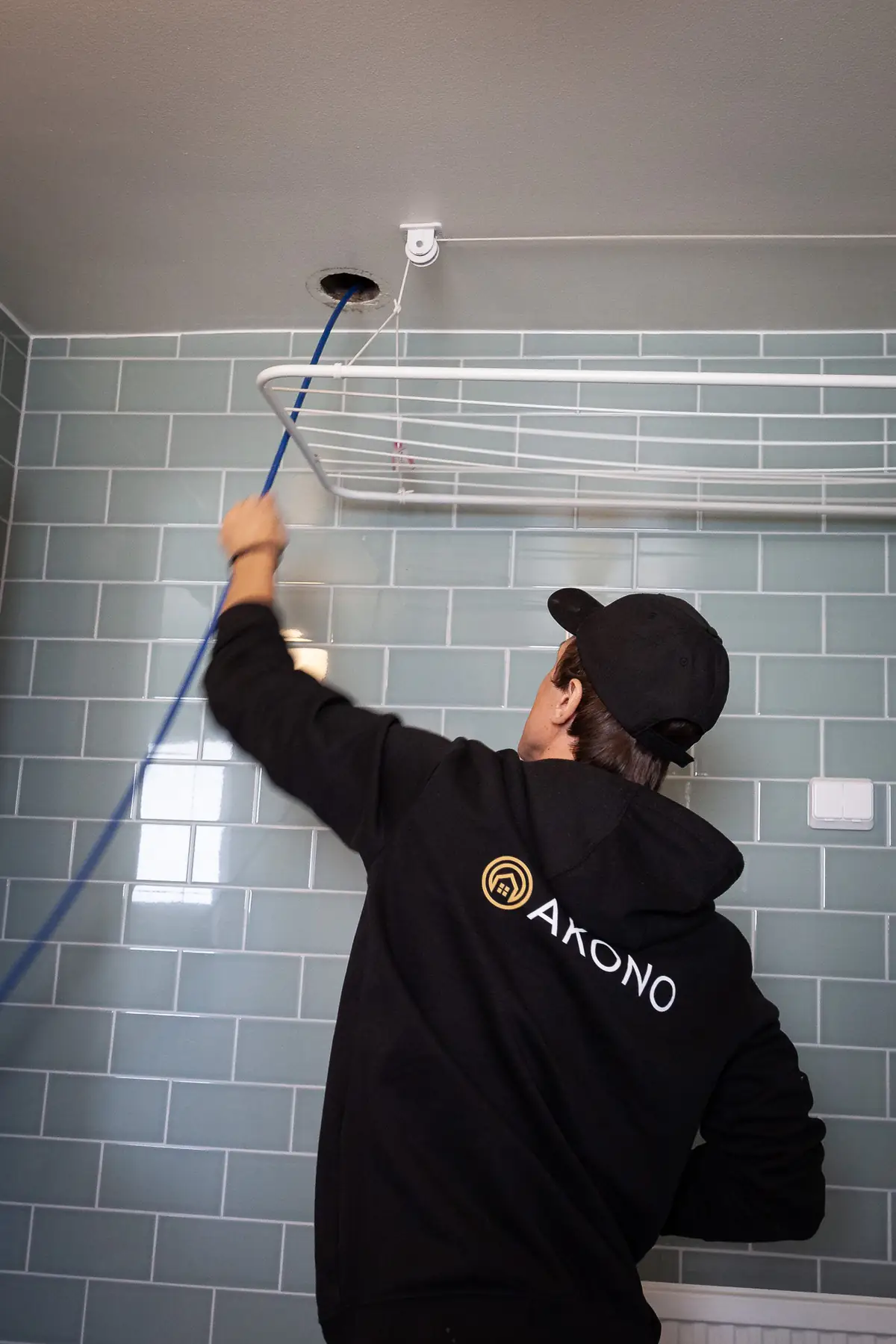 Akonos tekniker rensar en ventilationskanal i ett badrum